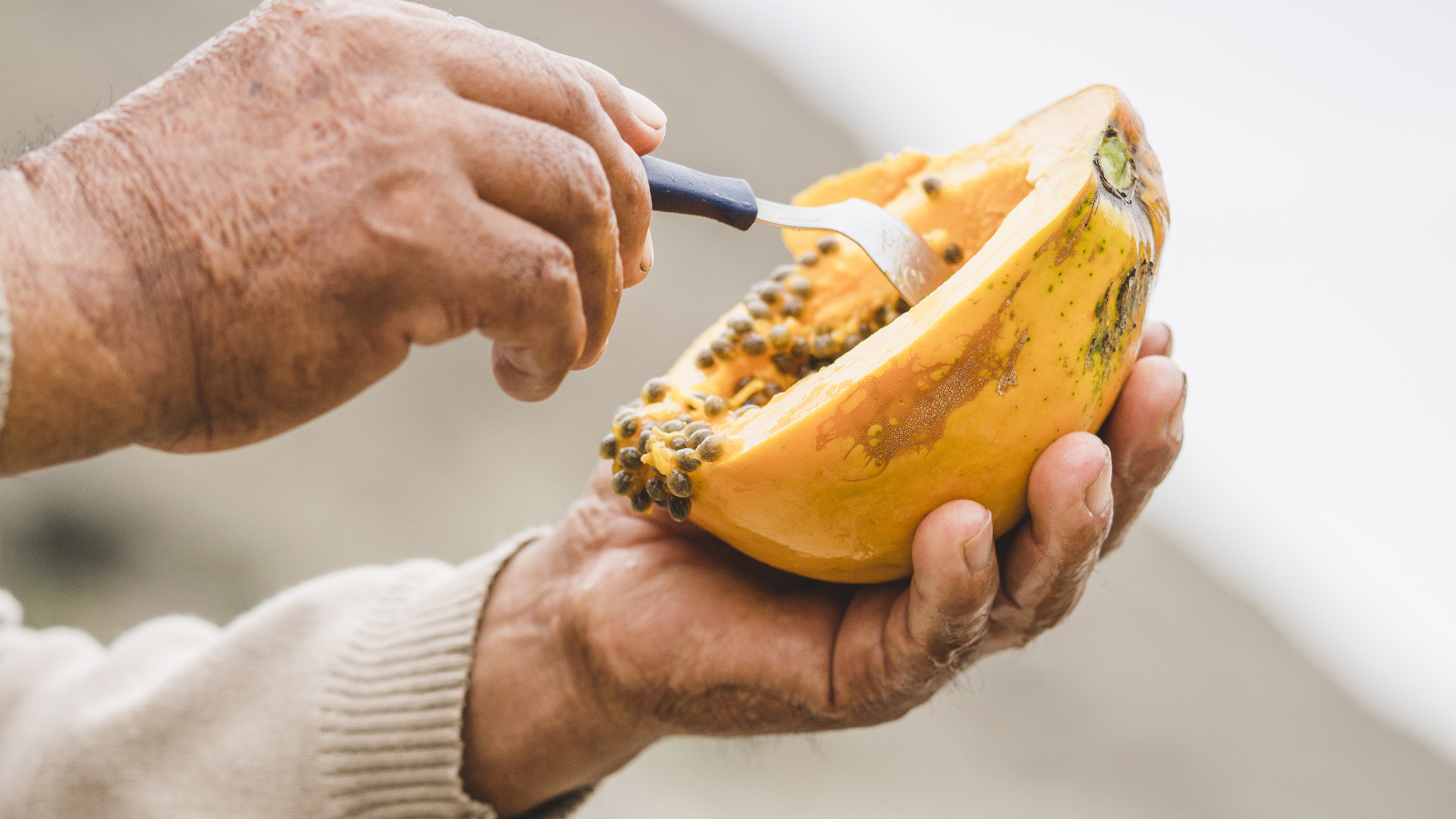 man eating papaya on the mountain